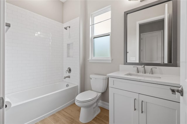 full bathroom with vanity, hardwood / wood-style flooring, toilet, and tiled shower / bath