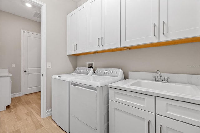 laundry room with cabinets, separate washer and dryer, light hardwood / wood-style flooring, and sink