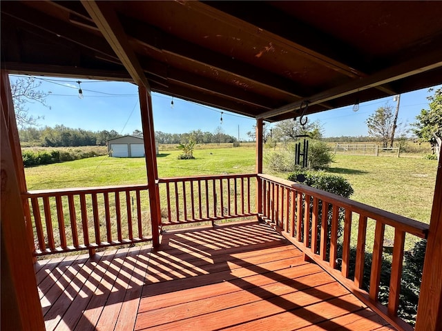 wooden deck with a rural view, a storage unit, and a yard