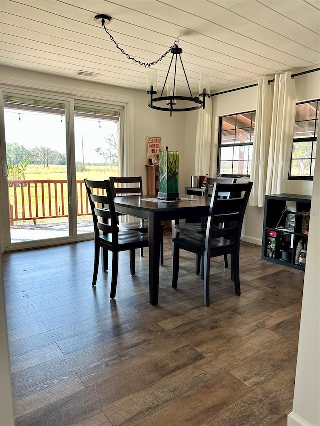 dining area featuring dark hardwood / wood-style flooring, a chandelier, and wooden ceiling