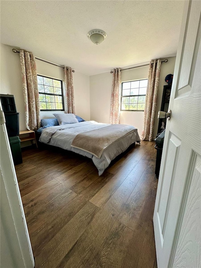 bedroom featuring dark wood-type flooring and a textured ceiling