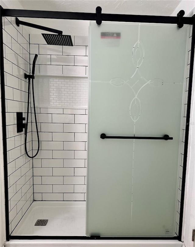 bathroom with a shower with door