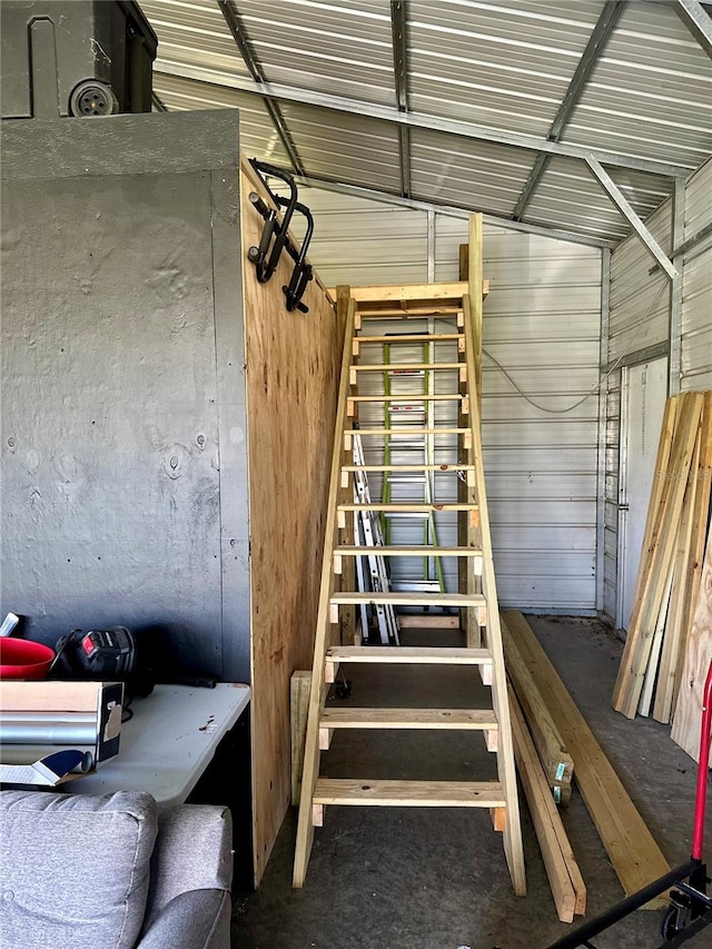 stairway featuring concrete floors and vaulted ceiling