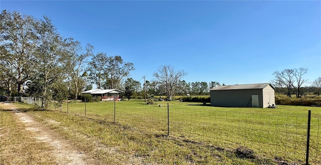 view of yard featuring a rural view and a storage shed