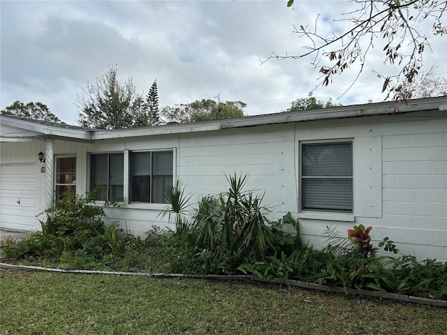 view of property exterior with a garage and a lawn