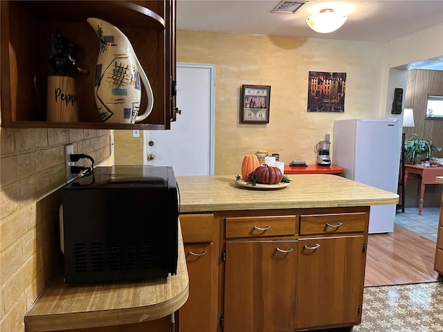 kitchen featuring light wood-type flooring and white refrigerator