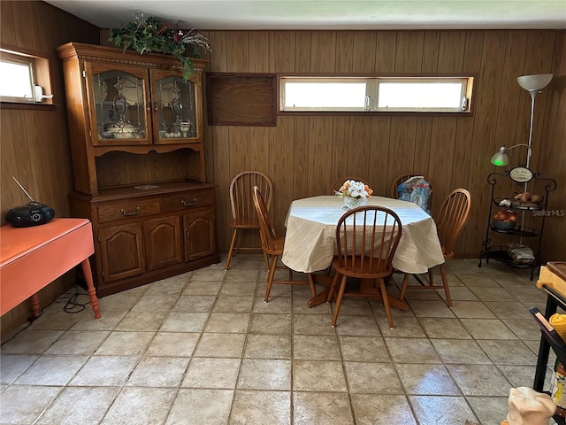 dining area with wooden walls and a healthy amount of sunlight