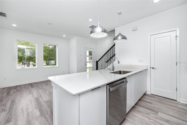 kitchen with dishwasher, sink, kitchen peninsula, pendant lighting, and light wood-type flooring