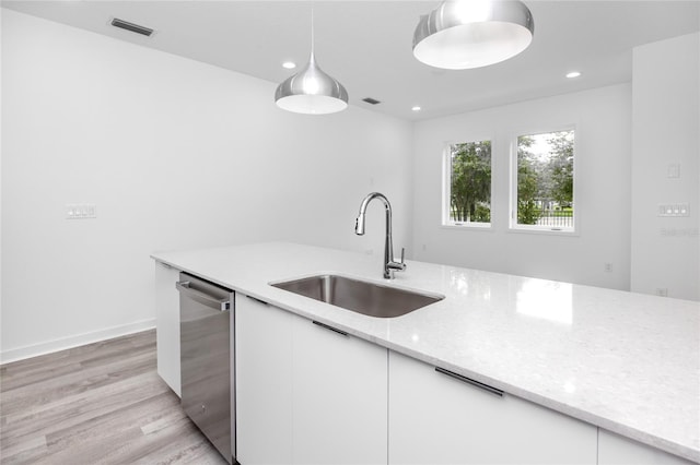 kitchen featuring white cabinets, dishwasher, sink, and decorative light fixtures