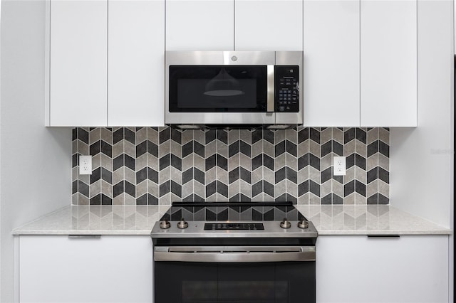 kitchen featuring white cabinets, appliances with stainless steel finishes, and backsplash