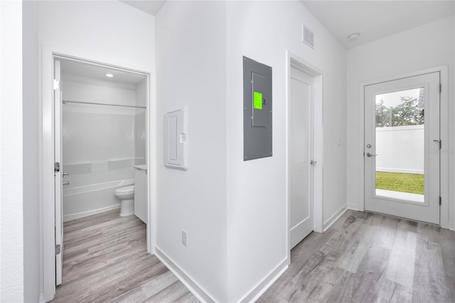 corridor featuring light wood-type flooring and electric panel