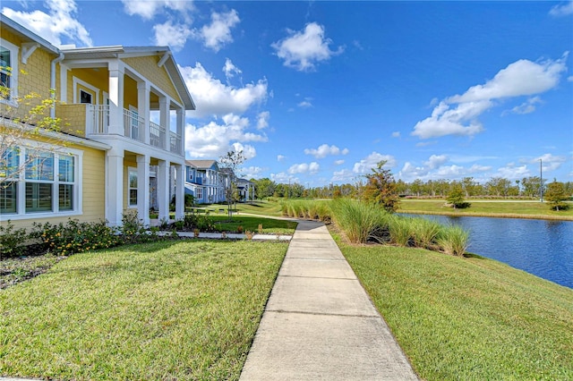 view of yard with a balcony and a water view