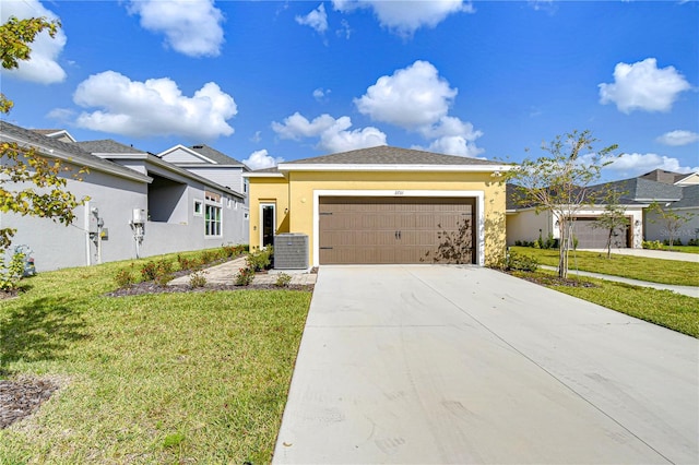 view of front of property with a front yard, central AC, and a garage