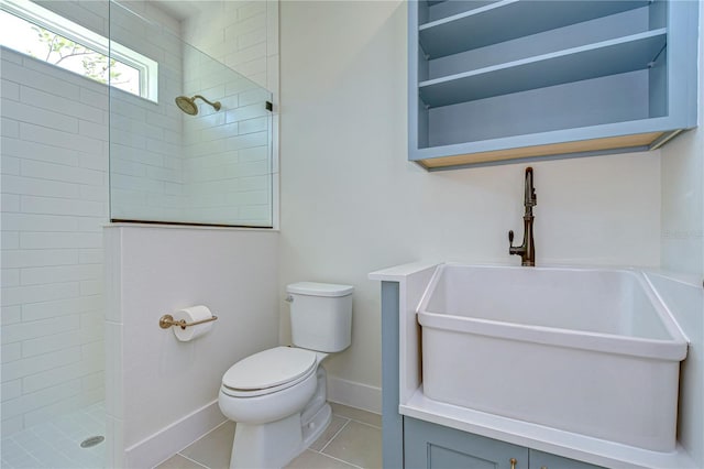 bathroom featuring tile patterned floors, a tile shower, and toilet