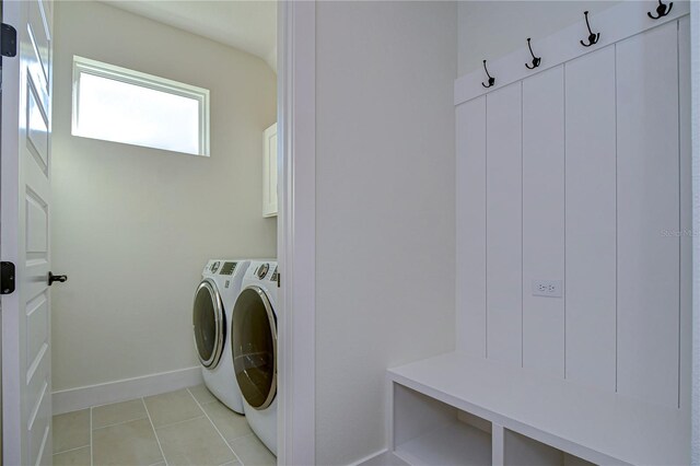 laundry area featuring cabinets, separate washer and dryer, and light tile patterned floors