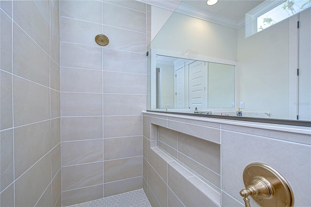 bathroom featuring a tile shower and crown molding