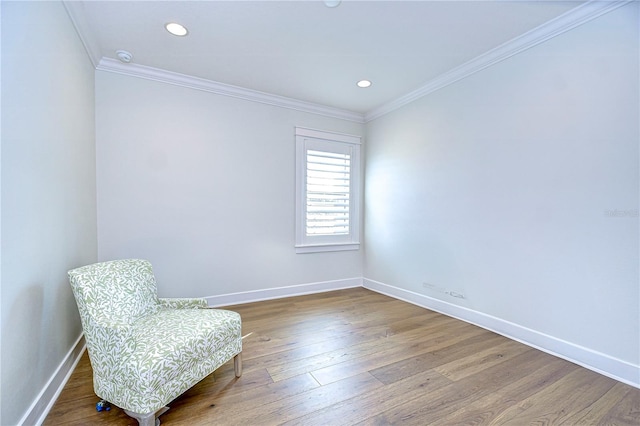 living area with hardwood / wood-style floors and ornamental molding