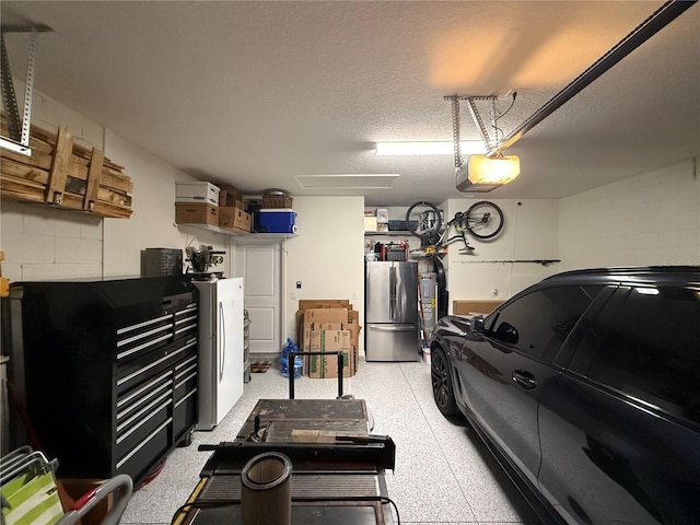 garage featuring stainless steel refrigerator and a garage door opener