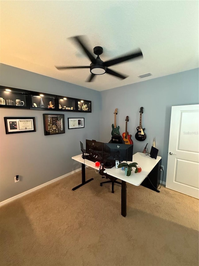 carpeted office space featuring ceiling fan