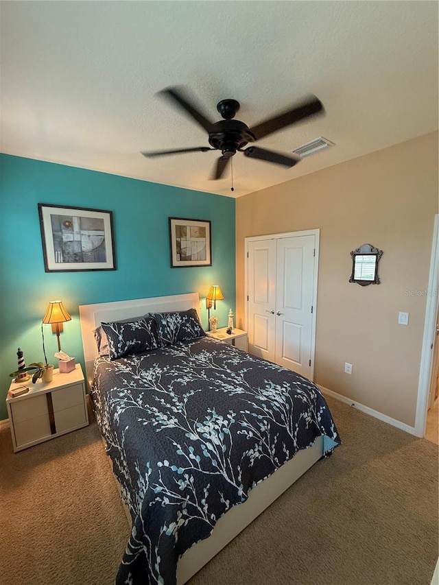 carpeted bedroom with ceiling fan and a closet