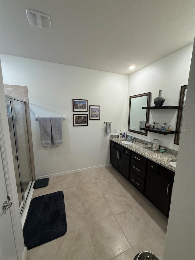 bathroom featuring tile patterned flooring, vanity, and a shower with door