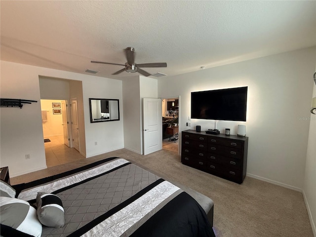 bedroom with connected bathroom, a textured ceiling, light carpet, and ceiling fan