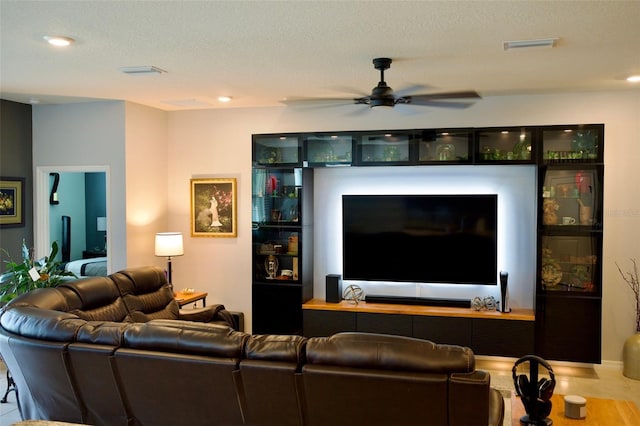 living room with a textured ceiling and ceiling fan