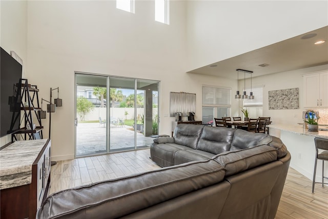 living room with light hardwood / wood-style flooring and a high ceiling