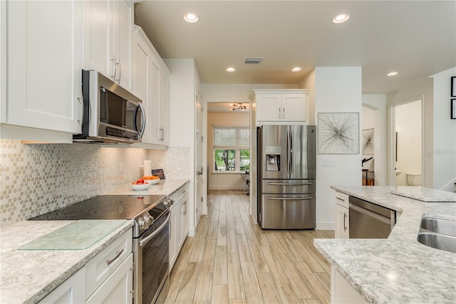 kitchen featuring white cabinetry, appliances with stainless steel finishes, and light stone countertops