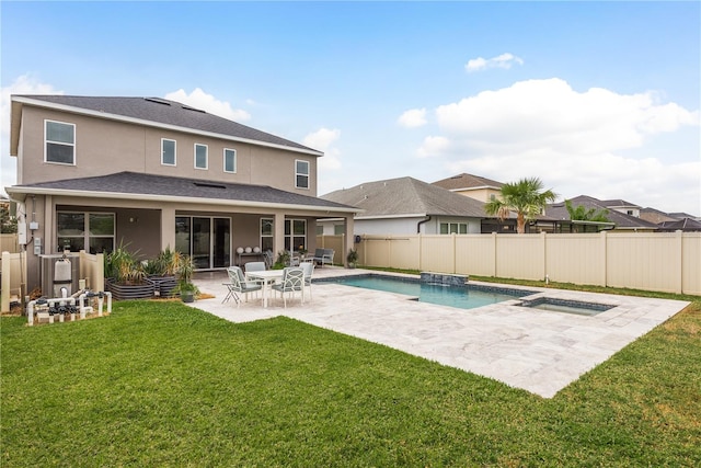 back of property featuring a pool with hot tub, a yard, and a patio area