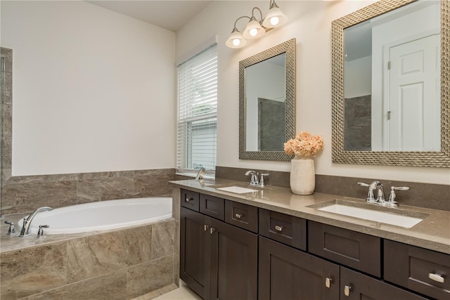 bathroom with tiled tub and vanity