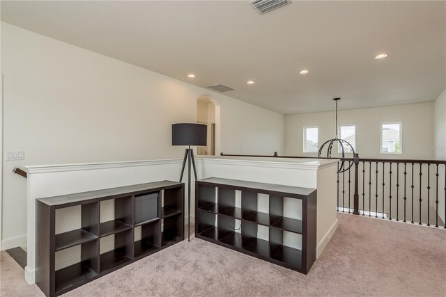 hall with light colored carpet