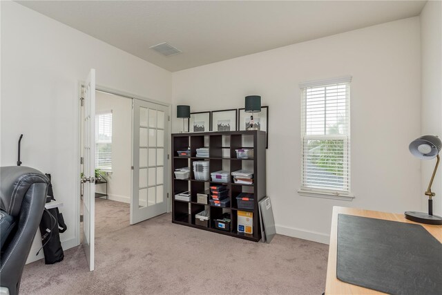 carpeted home office featuring french doors