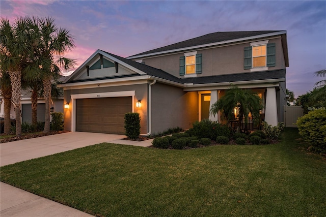 view of front of property with a garage and a yard