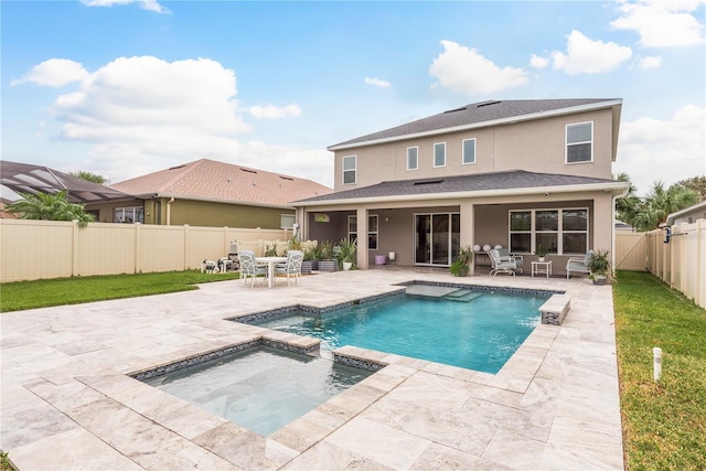 back of house with a swimming pool with hot tub and a patio