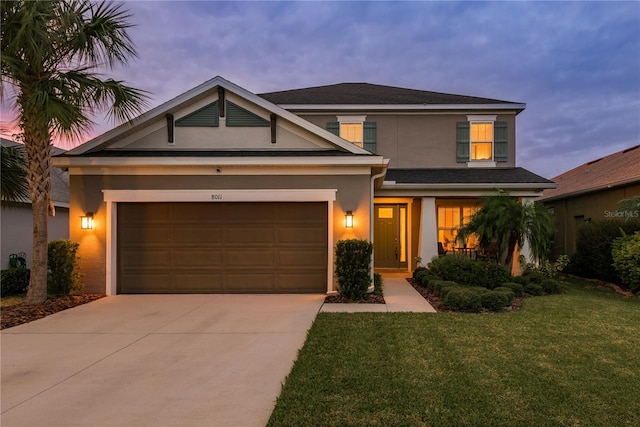 view of front of property with a garage and a lawn