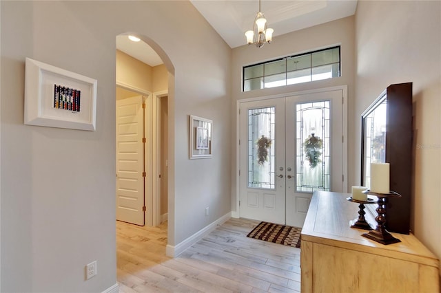 entrance foyer with a towering ceiling, light wood-type flooring, and a wealth of natural light