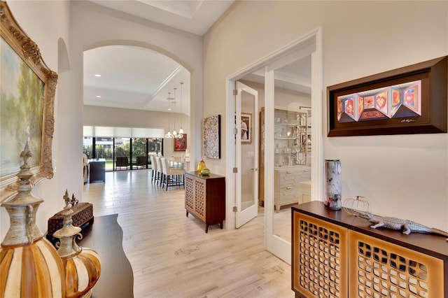 hall featuring light hardwood / wood-style floors and a notable chandelier