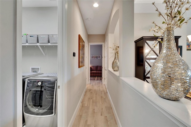 hallway with washing machine and clothes dryer and light hardwood / wood-style flooring