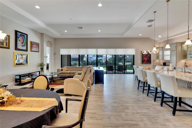 dining space featuring a tray ceiling and light hardwood / wood-style floors