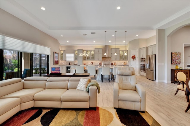 living room featuring light wood-type flooring and crown molding