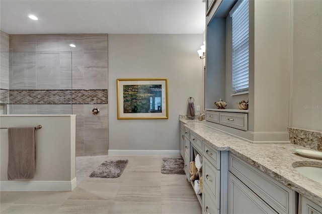 bathroom featuring tile patterned flooring, vanity, and a shower