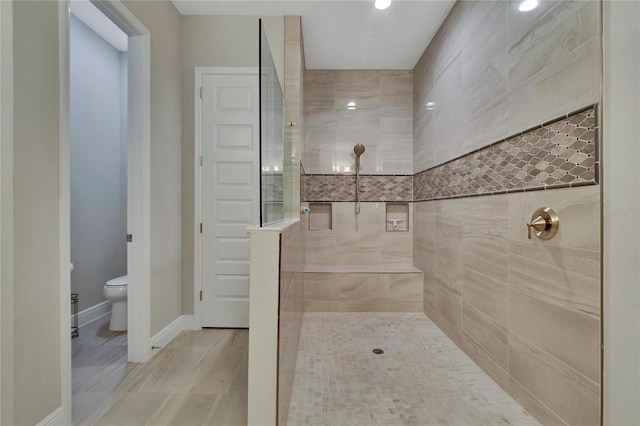 bathroom featuring toilet and tiled shower