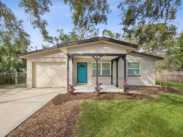 ranch-style home with a garage, covered porch, and a front lawn