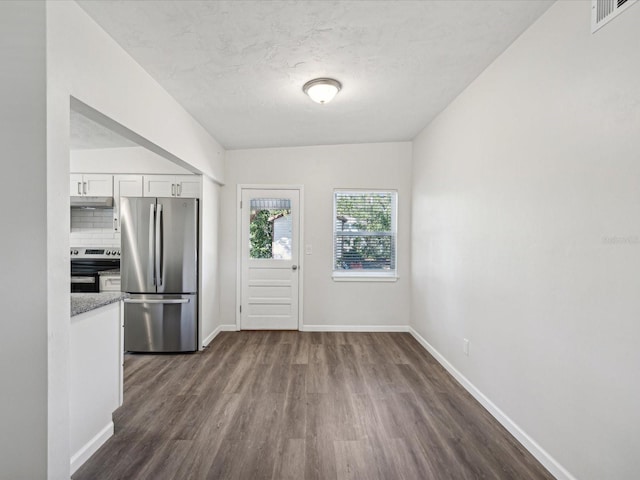 kitchen with stainless steel appliances, dark wood-type flooring, tasteful backsplash, light stone countertops, and white cabinetry