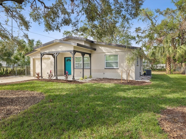 view of front of home featuring central AC unit and a front yard