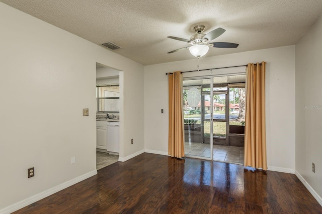 unfurnished room featuring baseboards, visible vents, a ceiling fan, wood finished floors, and a sink