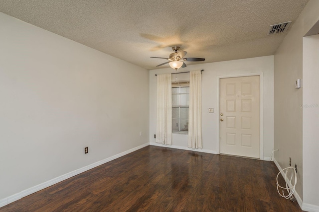 empty room featuring baseboards, ceiling fan, visible vents, and wood finished floors