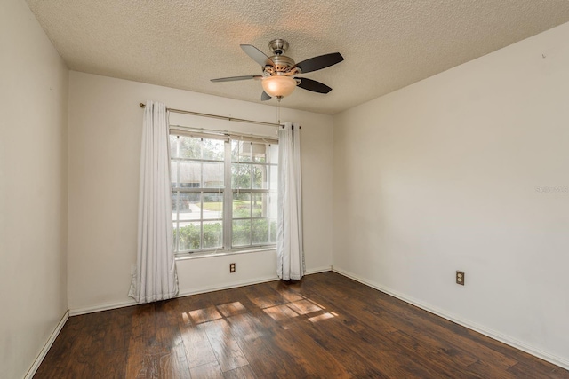 unfurnished room featuring dark wood-style floors, ceiling fan, a textured ceiling, and baseboards