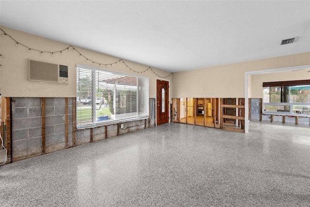 unfurnished living room with a wall mounted AC